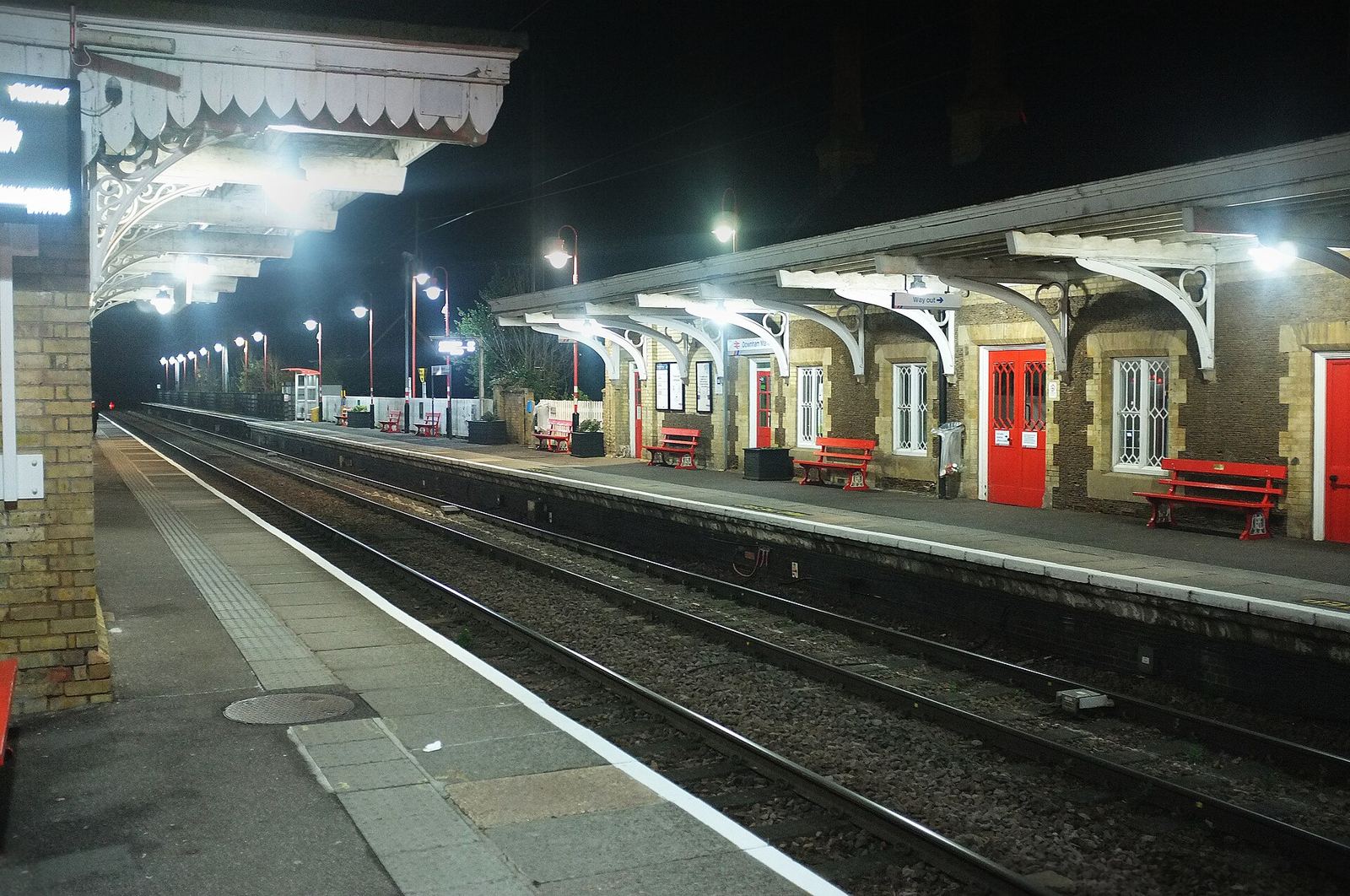 An empty railway platform lit at night