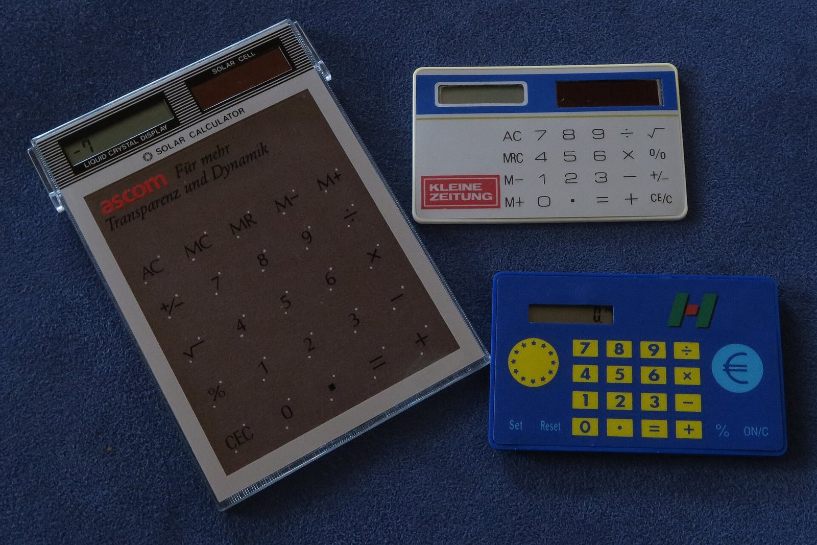 Two pocket calculators on a dark surface