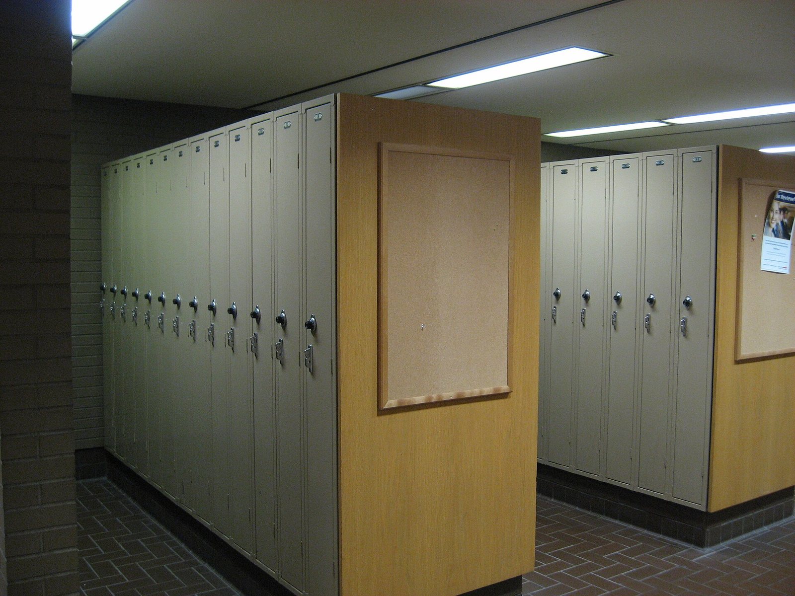 A row of metal lockers in a basement corridor