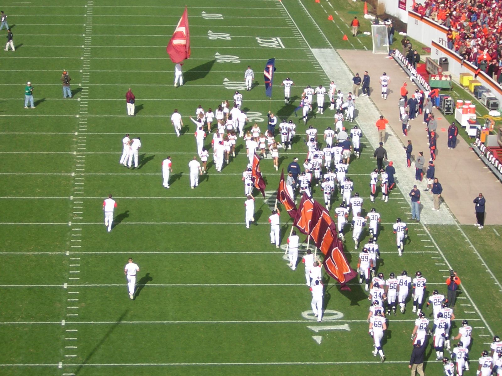 A marching band and cheerleaders on an American football field before kick-off