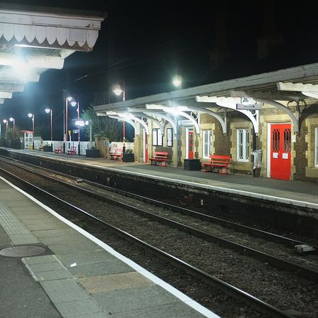 An empty railway platform lit at night