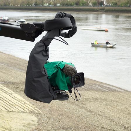 A broadcast camera on a jib arm covering a race on the water