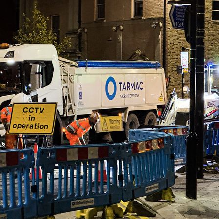 Night road works with ROAD CLOSED signs, barriers and a tipper lorry