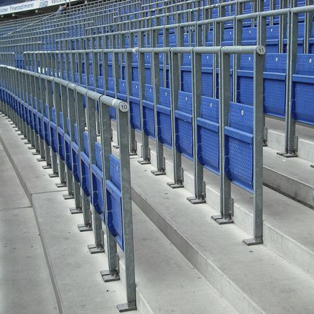 Rows of blue rail seats with waist-high barriers