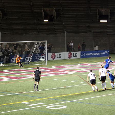 A penalty kick being saved, goalkeeper diving to his left